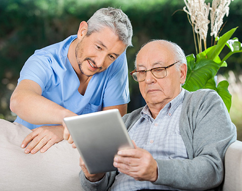 Executive Home Care staff helping client with tablet